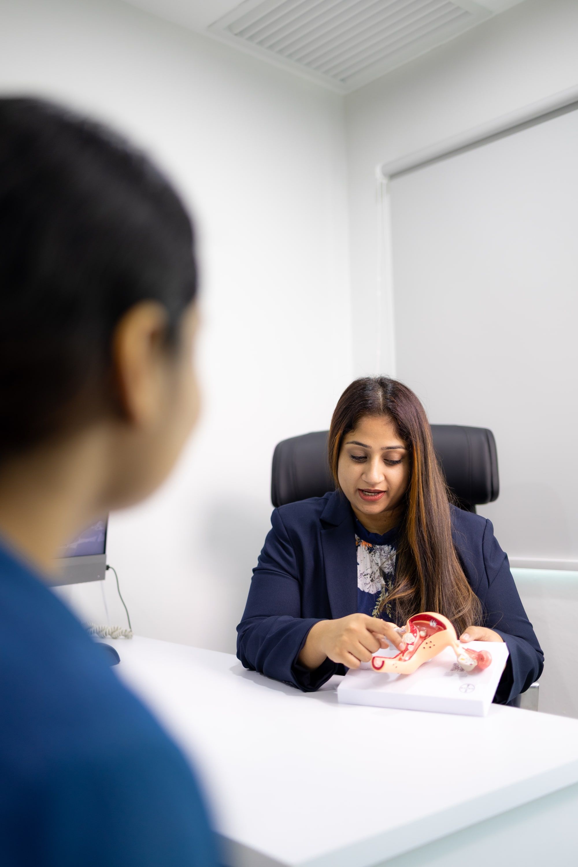 Dr Bheena Vyjhallaja pointing to an anatomical model of the uterus and ovaries while talking it through