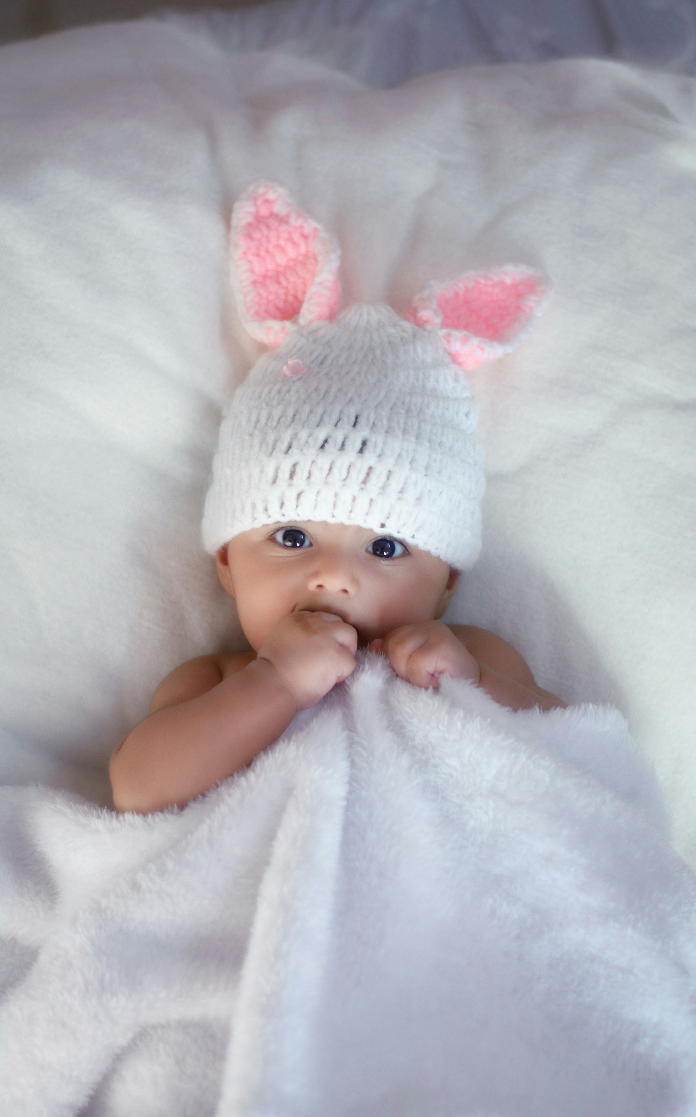 A newborn baby asleep, wrapped, seen close up.